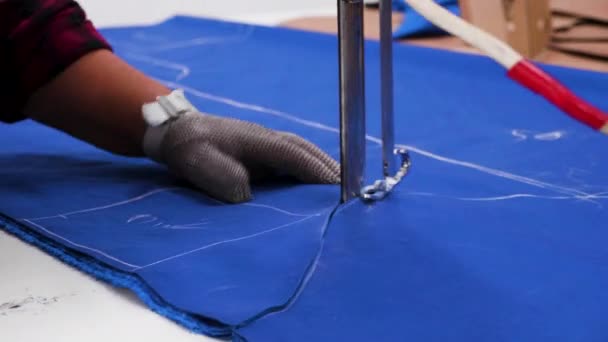 Женщина-работница на тканевой фабрике с помощью дискового ножа режет ткань — стоковое видео