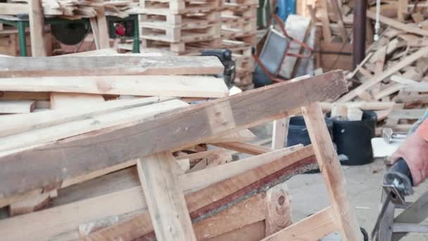 Mann zersägt Holzpalette in Wohnhaus mit der Motorsäge — Stockvideo