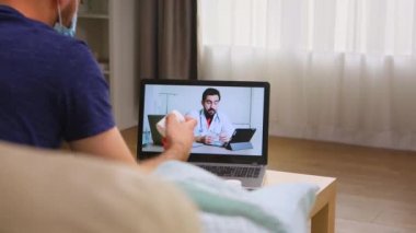 Adamın biri doktoruyla çevrimiçi görüşme yapıyor.