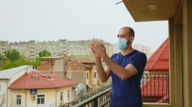 Maskeli neşeli adam alkışlıyor.