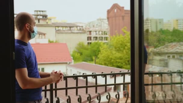 Man probeert te ontspannen op het balkon van zijn appartement — Stockvideo