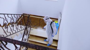 Tehlikeli madde giysisi içindeki biyolog dezenfektan püskürttü.