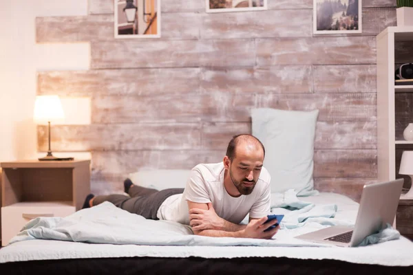 Egy férfi az ágyban, pizsamában. — Stock Fotó