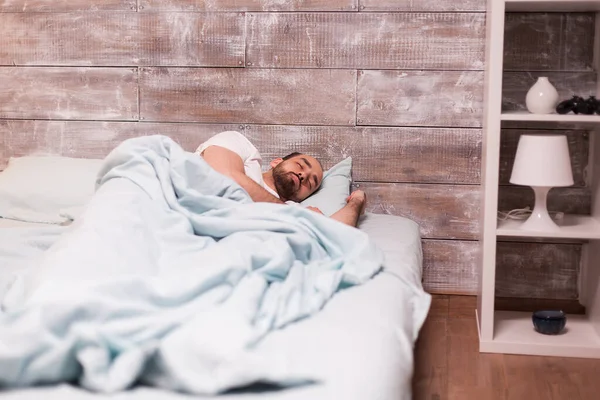 Unavený muž spí na pohodlné posteli — Stock fotografie