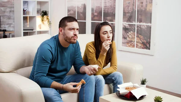 Geconcentreerd jong paar eten gebakken kip — Stockfoto