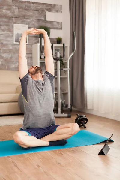 Fit man op yoga mat stretching zijn rug — Stockfoto