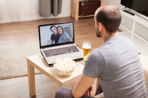 Homem em uma chamada de vídeo com seus amigos — Fotografia de Stock