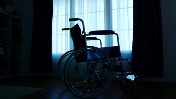 Silueta de la silla de ruedas del hospital en habitación oscura — Vídeos de Stock