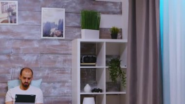 Yatağında dijital tablet üzerinde çalışan serbest çalışan biri.