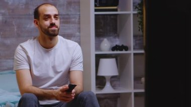 Kafkasyalı bir adam gece geç saatte televizyon izliyor.