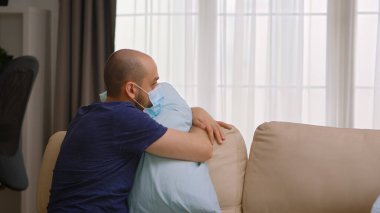 Kovid 19 'a yakalanmış bir adam maske takıyor.