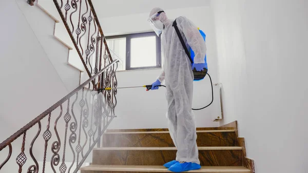 Hombre en traje de materiales peligrosos pulverización química —  Fotos de Stock