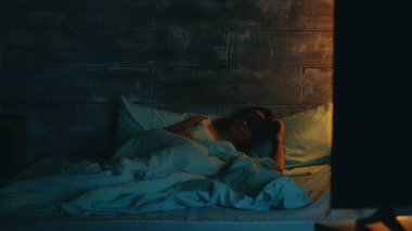 Pijamalı bir kadın telefon uygulamasının ışığını kapatıyor.