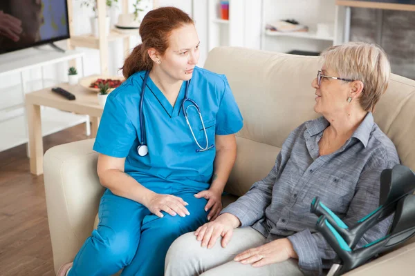 Health visitor with stethoscope on a couch in a nursing home — Stock Photo, Image