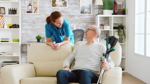 Retired man in nursing home talking with a nurse
