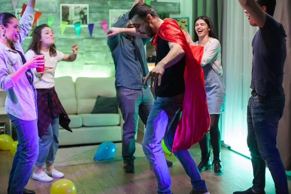 Grupo de amigos animando a su amigo vestido como un superhéroe — Foto de Stock