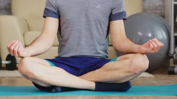 Egy srác jógázik otthon. — Stock videók