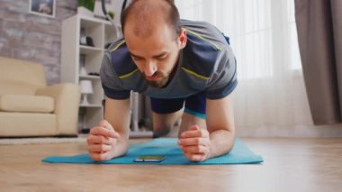 Fitness elemanı kalas egzersizi yapıyor.