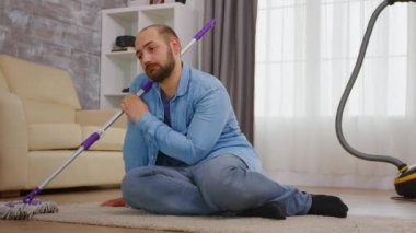 Yorgun adam ev işlerini yapıyor.