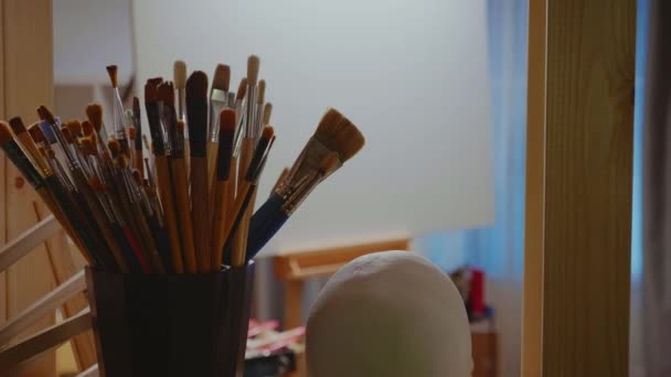 Burlarse en el estudio de arte con caballete — Vídeo de stock