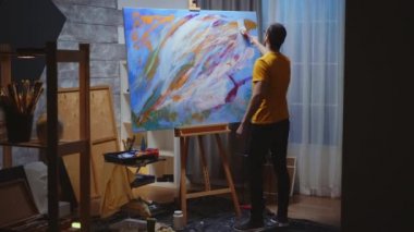 Sanat stüdyosundaki adam sanatçı.
