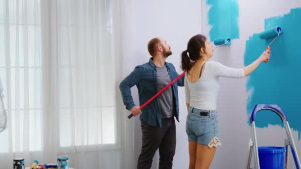 Parede de pintura jovem casal com escova de rolo — Vídeo de Stock