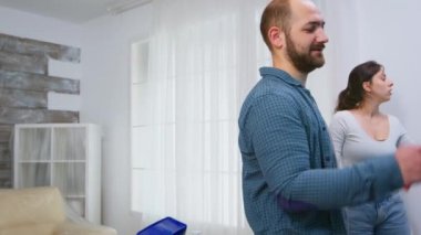 Duvarı boyarken çift konuşuyor.