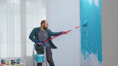 Ev onarımı sırasında şarkı söyleyen adam.