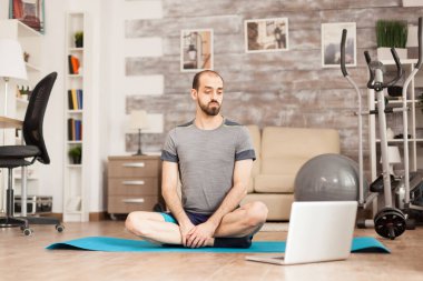 Formda adam internetten yoga öğreniyor.