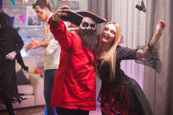 Mujer vampiro feliz y hombre pirata tomando una selfie — Foto de Stock