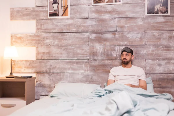 Cansado homem usando uma máscara de sono — Fotografia de Stock