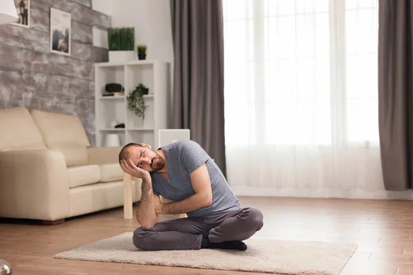 Nudný muž sedí na koberci v obývacím pokoji — Stock fotografie