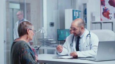 Doktor yaşlı, emekli bir kadına danışıyor.