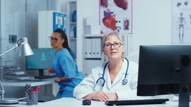 Experimentado médico señora mayor sonriendo a la cámara — Vídeos de Stock