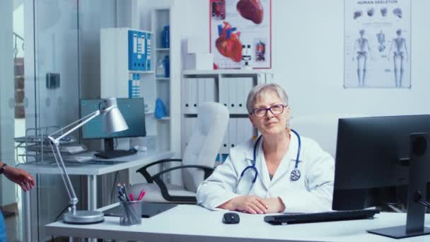 Mujer mayor médico sonriendo a la cámara — Vídeos de Stock