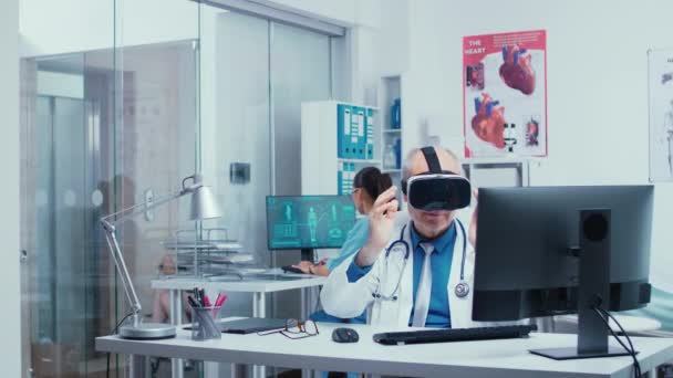 Starší lékař používající brýle VR na moderní soukromé klinice — Stock video