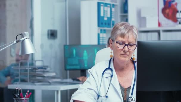 Portret van oudere doktersvrouw aan het werk — Stockvideo