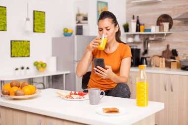 Meyve suyu içerken telefona bakmak.