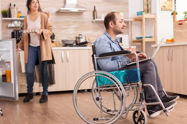 Homem com deficiência em cadeira de rodas durante videochamada — Fotografia de Stock