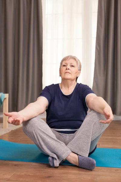 Portrait of old woman practicing yoga