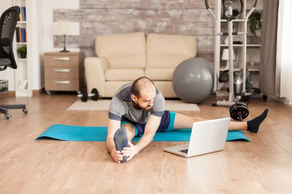 Atletische man stretching op yoga mat — Stockfoto