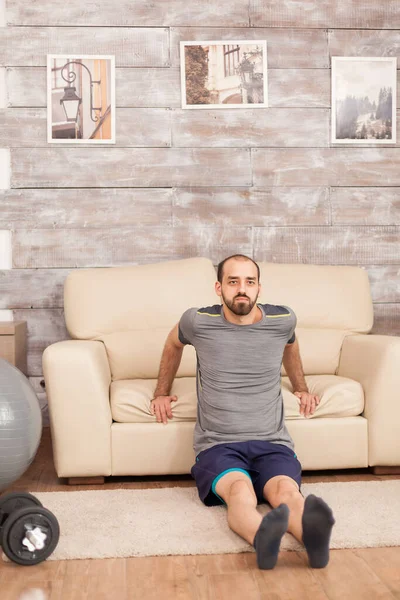 Fit man met sofa om triceps te trainen — Stockfoto