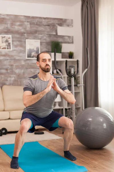 Fit man in sportkleding doet squats — Stockfoto