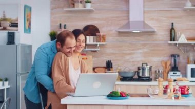 Karısı dizüstü bilgisayarda okuyor.