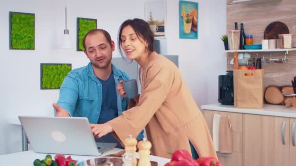 Frau blickt auf Laptop ihres Mannes — Stockvideo