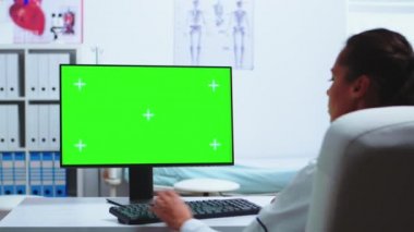 Doktor yeşil ekranlı bilgisayarda çalışıyor