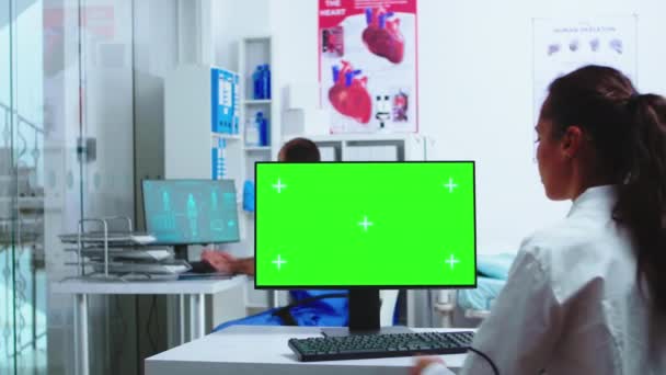 Врач с помощью компьютера с зеленым макетом — стоковое видео