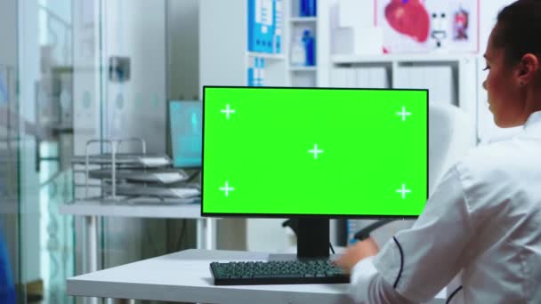 Doctor zit achter de computer met blanco display — Stockvideo