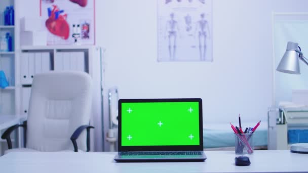 Ordenador portátil en el gabinete del hospital con pantalla verde — Vídeos de Stock