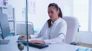 Hastane dolabında beyaz önlük giyen doktor.
